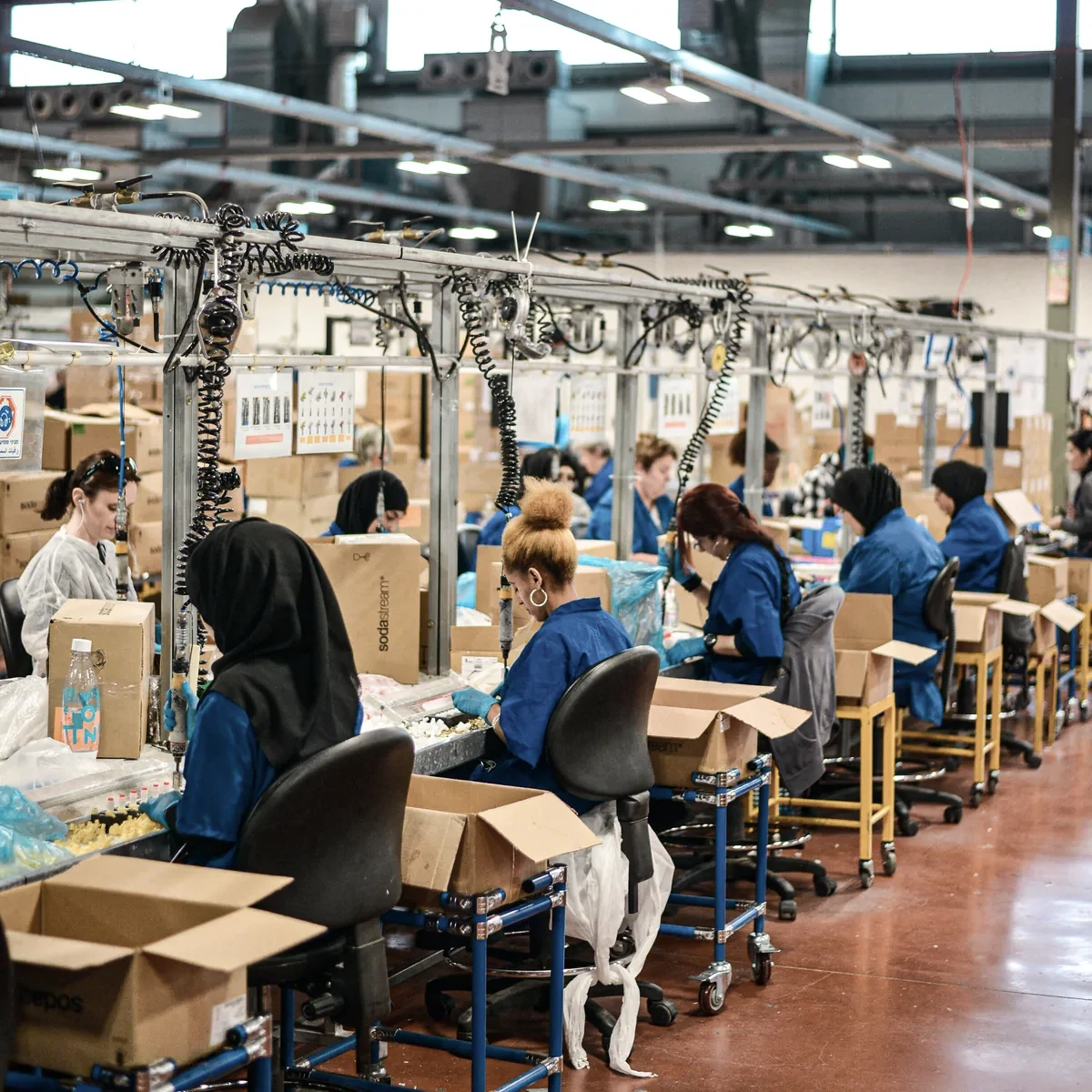 Technicians working at assembly stations in a production facility