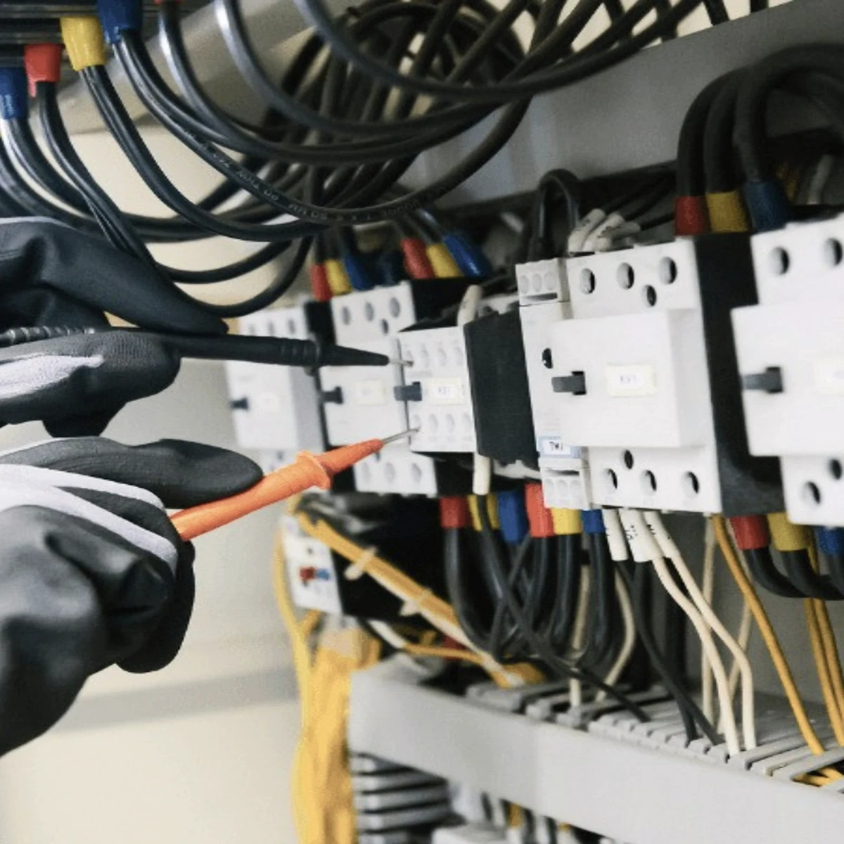 Technician testing a power control panel with a multimeter
