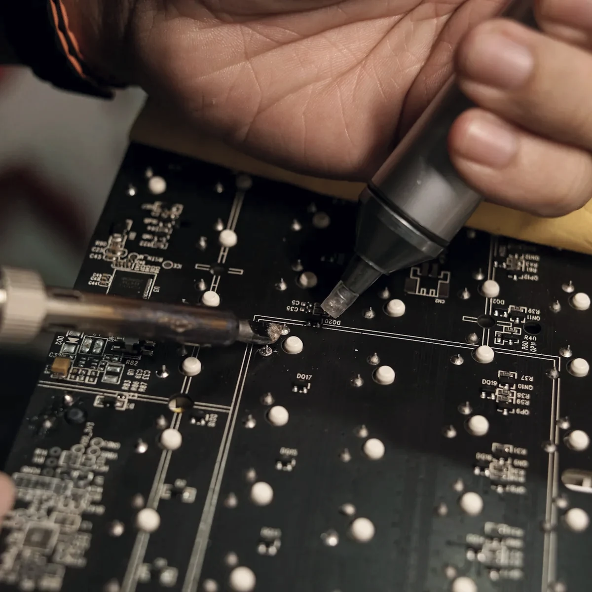 Technician reworking a circuit board with a soldering iron
